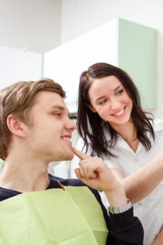 Dental patient looking at his smile in mirror