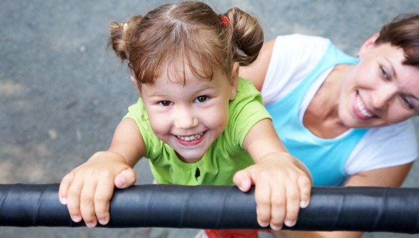 Young girl in pigtails playing on playground after children's dentistry in Arundel