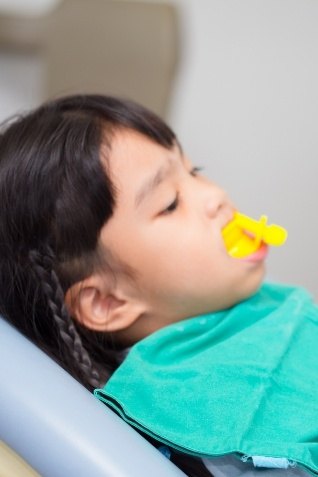 Child receiving silver diamine fluoride in dental office