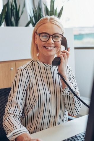 Dental team member smiling while talking on phone