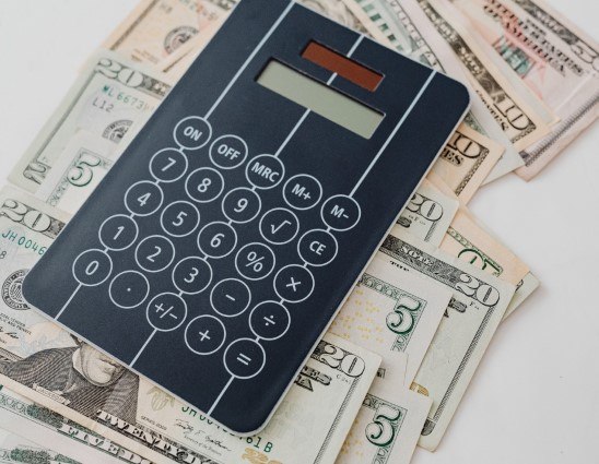 Calculator and cash on white background