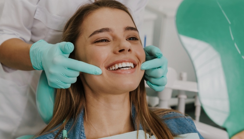 Young woman smiling while visiting her dentist in Arundel