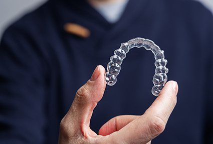 Man holding up clear aligner