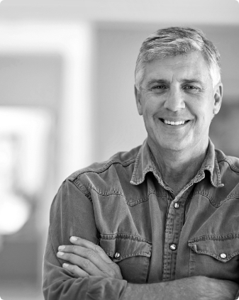 Smiling older man standing with his arms crossed