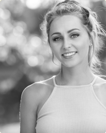 Blonde woman grinning with trees in background