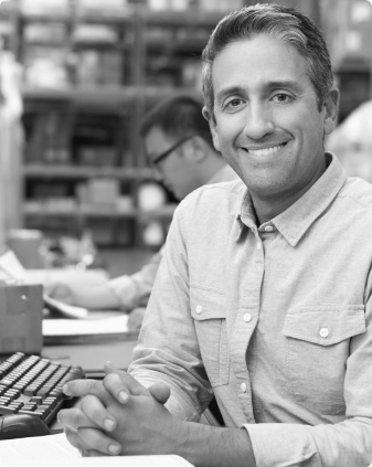 Smiling older man sitting at desk with computer