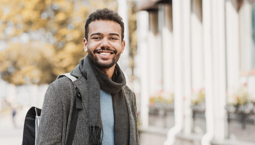 Man in scarf smiling after preventive dentistry in Arundel