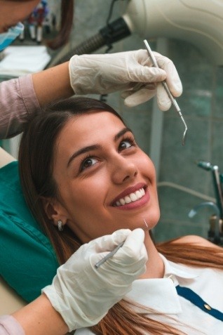 Woman smiling at dentist during preventive dentistry checkup