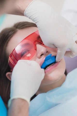 Young woman receiving fluoride treatment during dental checkup