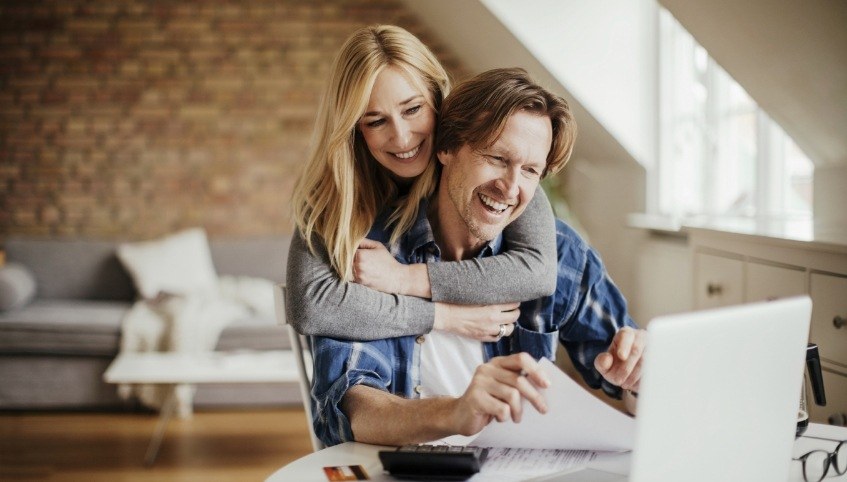 Man and woman looking at laptop to read dentist reviews in Arundel