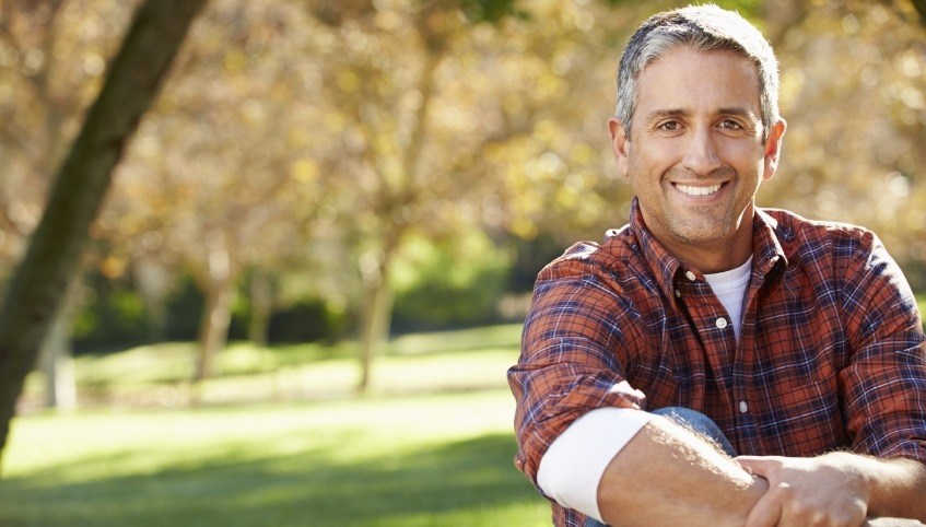 Man in plaid shirt smiling outdoors after root canal treatment in Arundel