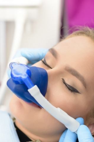 Young woman with eyes closed wearing nose mask for nitrous oxide sedation dentistry